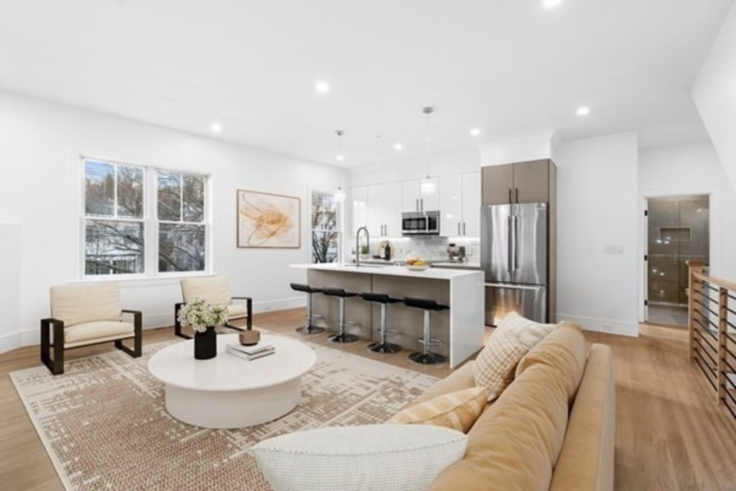 Open living room and kitchen with a center island and breakfast seating.