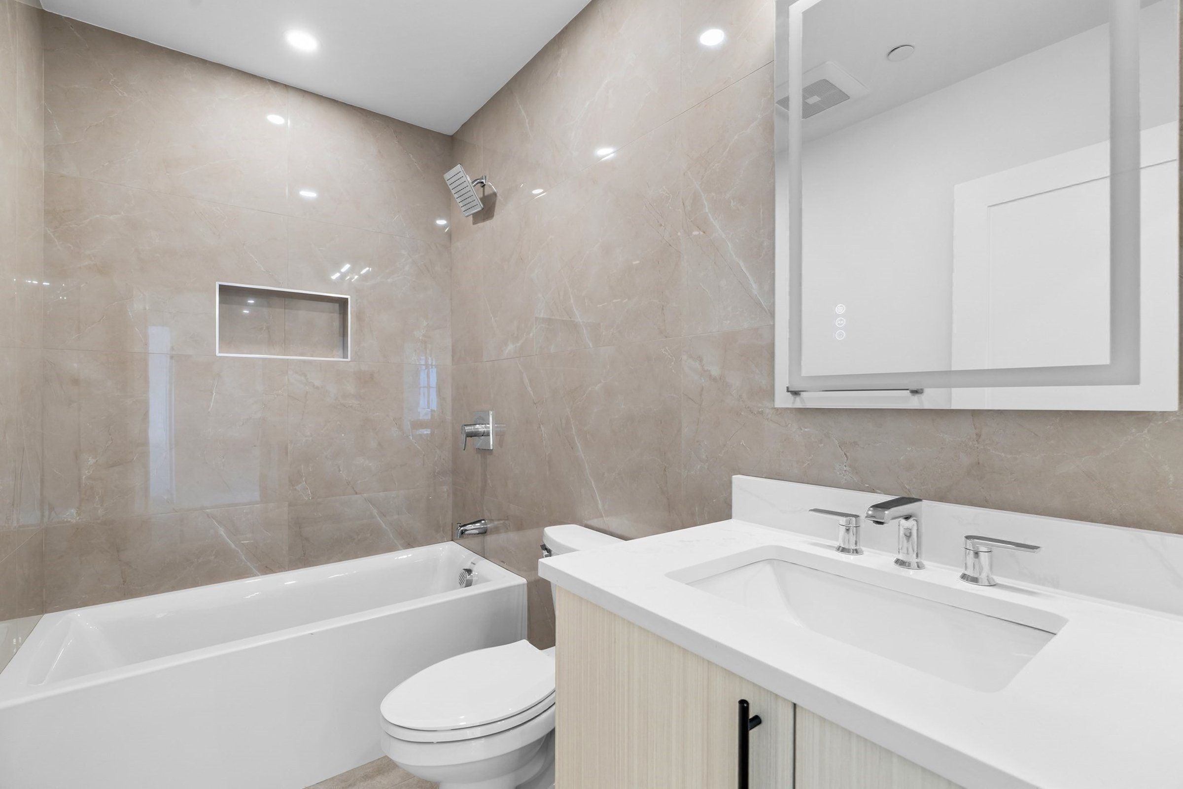 Full bathroom with a soaking tub and marble-tiled surround.