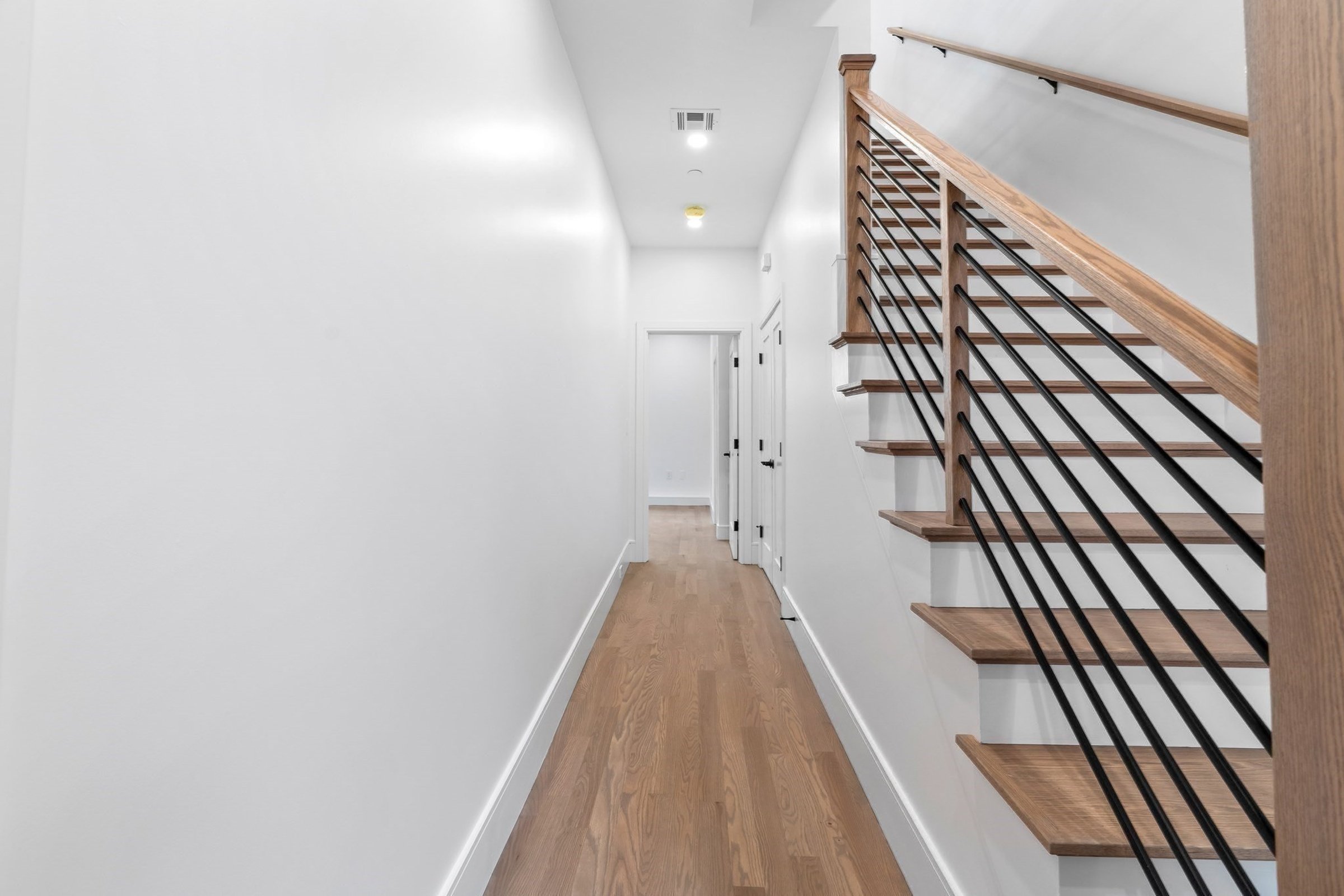 Hallway alongside the oak and black-metal staircase.