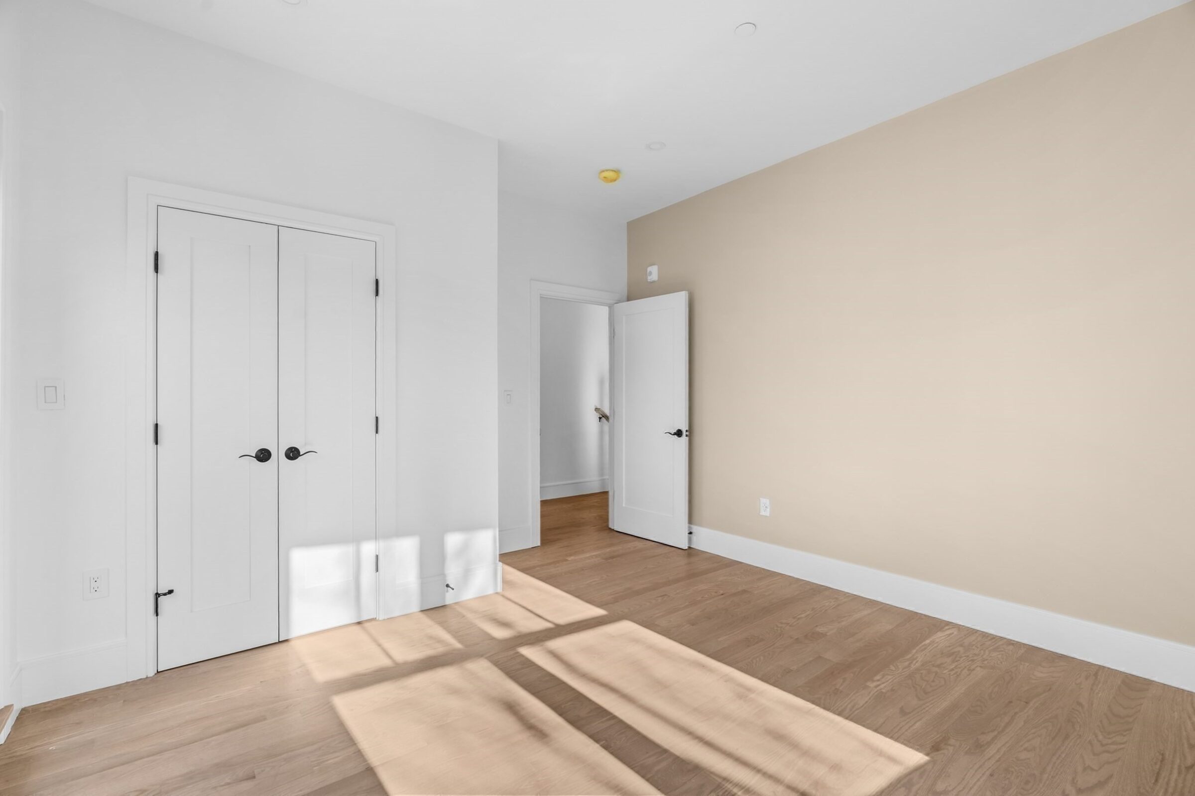 Bedroom with a double-door closet and oak flooring.